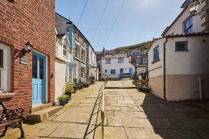an alley with buildings and a bench on a street at Host & Stay - Sea Haven in Staithes