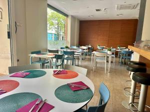 a restaurant with tables and chairs with purple and green napkins at Apartamentos Plaza Picasso in Valencia