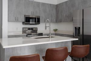 a kitchen with a sink and a counter with chairs at South Downtown Condo no.308 in Dallas