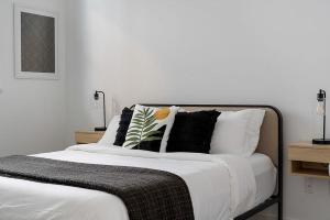 a white bed with black and white pillows on it at South Downtown Condo no.308 in Dallas