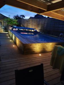a swimming pool with lights on a deck at night at Chez cococuisine in Les Nouillers