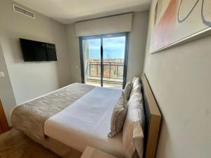 a bedroom with a bed and a large window at Apartamentos Plaza Picasso in Valencia