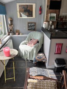 a room with a kitchen with a chair and a table at Cottage Sleeps 4 with Wifi in Llanfairpwllgwyngyll
