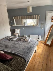 a bedroom with a bed with a cat laying on it at Cottage Sleeps 4 with Wifi in Llanfairpwllgwyngyll +2 photos