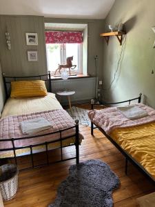 a bedroom with two beds and a dog in the window at Cottage Sleeps 4 with Wifi in Llanfairpwllgwyngyll