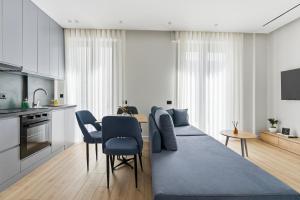 a kitchen and living room with a table and chairs at Le Mom Apart Hotel in Berat