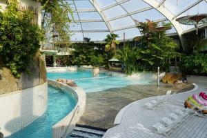a large swimming pool in a building with a glass ceiling at Zeevibes - Sunparks - Waterpret - gratis fietsen! in Oostduinkerke