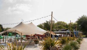 a large white tent in front of a playground at Zeevibes - Sunparks - Waterpret - gratis fietsen! in Oostduinkerke
