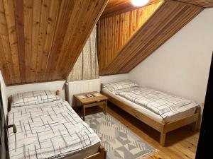 two beds in a room with wooden ceilings at Cabana Poiana in Rusca