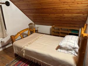 a bedroom with a bed and a wooden ceiling at Cabana Poiana in Rusca