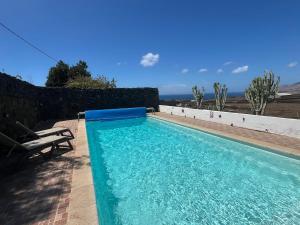 a blue swimming pool with a bench next to it at Casa Tara - 5 bedroom, 4 bathroom villa with private pool in Mácher