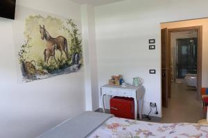 a bedroom with a painting of a horse on the wall at Casa Castegner - Rooms in Seren del Grappa