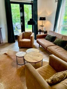 a living room with couches and chairs and tables at Forest Vacation Home -fenced garden- in Ewijk