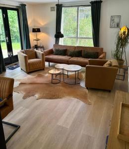 a living room with a couch and a table at Forest Vacation Home -fenced garden- in Ewijk