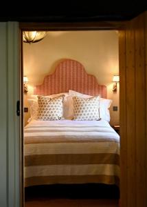 a bedroom with a large bed with a large headboard at Botley Hill Farmhouse in Warlingham +40 photos