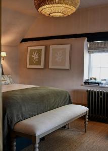 a bedroom with a bed and a window and a chandelier at Botley Hill Farmhouse in Warlingham