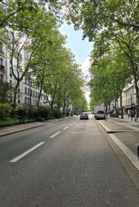 an empty street with cars driving down the road at Spacious Studio Paris La villette-Metro in Paris +2 photos
