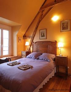 a bedroom with a large bed in a attic at La Berlandière in Le Merlerault