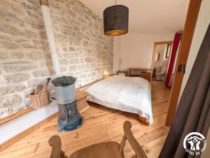 a bedroom with a bed and a stone wall at Chambres d'hotes lecortile in Villeneuve-lès-Maguelonne