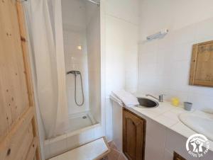 a white bathroom with a sink and a shower at Chambres d'hotes lecortile in Villeneuve-lès-Maguelonne