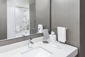 a bathroom with a sink and a large mirror at Courtyard by Marriott Wayne Fairfield in Wayne