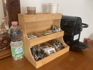 a wooden stand with a bottle of water next to a coffee maker at Antonio Rooms 2 in Parma