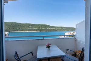 a table and chairs on a balcony with a view of the ocean at Villa Petra in Neum