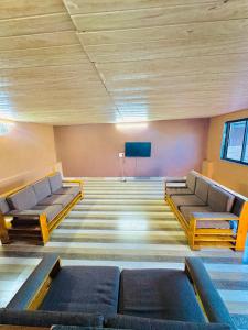 a large room with two couches and a tv at Baba s Villa in Lonavala