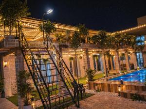a building with a ladder next to a swimming pool at Baba s Villa in Lonavala