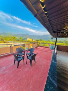 a patio with two chairs and a table on a roof at Baba s Villa in Lonavala