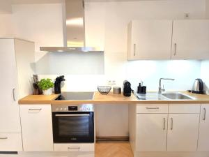 a kitchen with white cabinets and a black oven at Modernes Apartment im Herzen der Ravensburger Altstadt in Ravensburg +7 photos