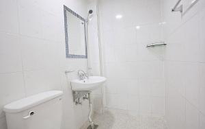 a white bathroom with a toilet and a sink at Kangchon Pine Tree Pension in Chuncheon +49 photos
