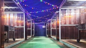 a corridor with lights and a green floor in a room at Daecheon Story Pension in Boryeong