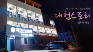 a car parked in front of a building at night at Daecheon Story Pension in Boryeong