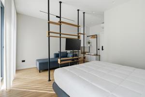 a bedroom with a large white bed and a tv at Le Mom Apart Hotel in Berat
