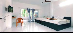 a bedroom with a bed and a chair and a window at ANS Green Villa in Yercaud +6 photos