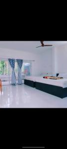 a white room with a bed and a window at ANS Green Villa in Yercaud