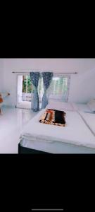 a bedroom with a white bed and a window at ANS Green Villa in Yercaud