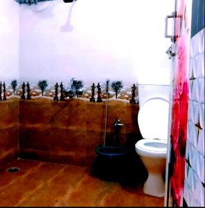 a bathroom with a toilet with a painting on the wall at ANS Green Villa in Yercaud