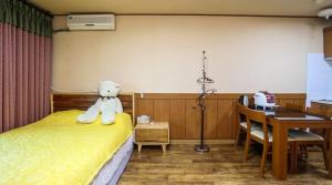 a teddy bear sitting on a bed in a room at Uljin blue ara A pension in Uljin +31 photos