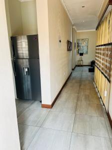 a hallway with a stainless steel refrigerator in a room at Ultimate Sky-2 bedroom villa in Pretoria