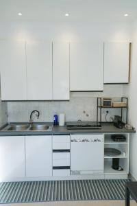 a kitchen with white cabinets and a sink at Blue Iris - Varese - Laghi Svizzera in Varese