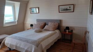 a bedroom with a bed with white sheets and pillows at L'ESTRAN in Saint-Valéry-sur-Somme
