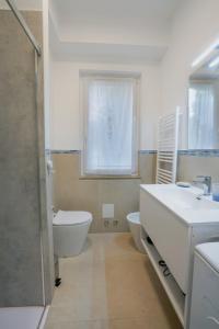 a bathroom with a sink and a toilet and a window at Blue Iris - Varese - Laghi Svizzera in Varese +22 photos