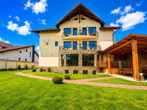 a large house with a green lawn at Vila Emerald Residence in Râşnov
