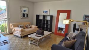 a living room with two couches and a table at Sunny Place Geneva 15 min Train in Versoix