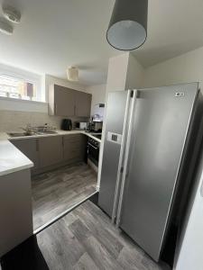 a kitchen with a stainless steel refrigerator at The M Rooms at 144 in Kirk of Shotts