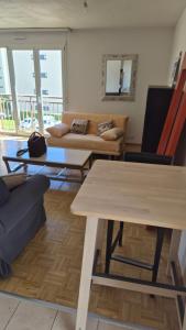 a living room with a table and a couch at Sunny Place Geneva 15 min Train in Versoix