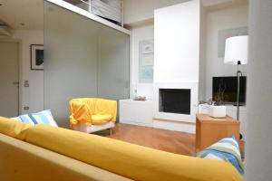 a living room with a yellow couch and a tv at SE251 - Marzocca, quadrilocale comodo al mare e ai servizi in Marzocca di Senigallia