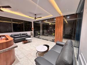 a living room with couches and tables and windows at Vantara Gir Resort in Sasan Gir